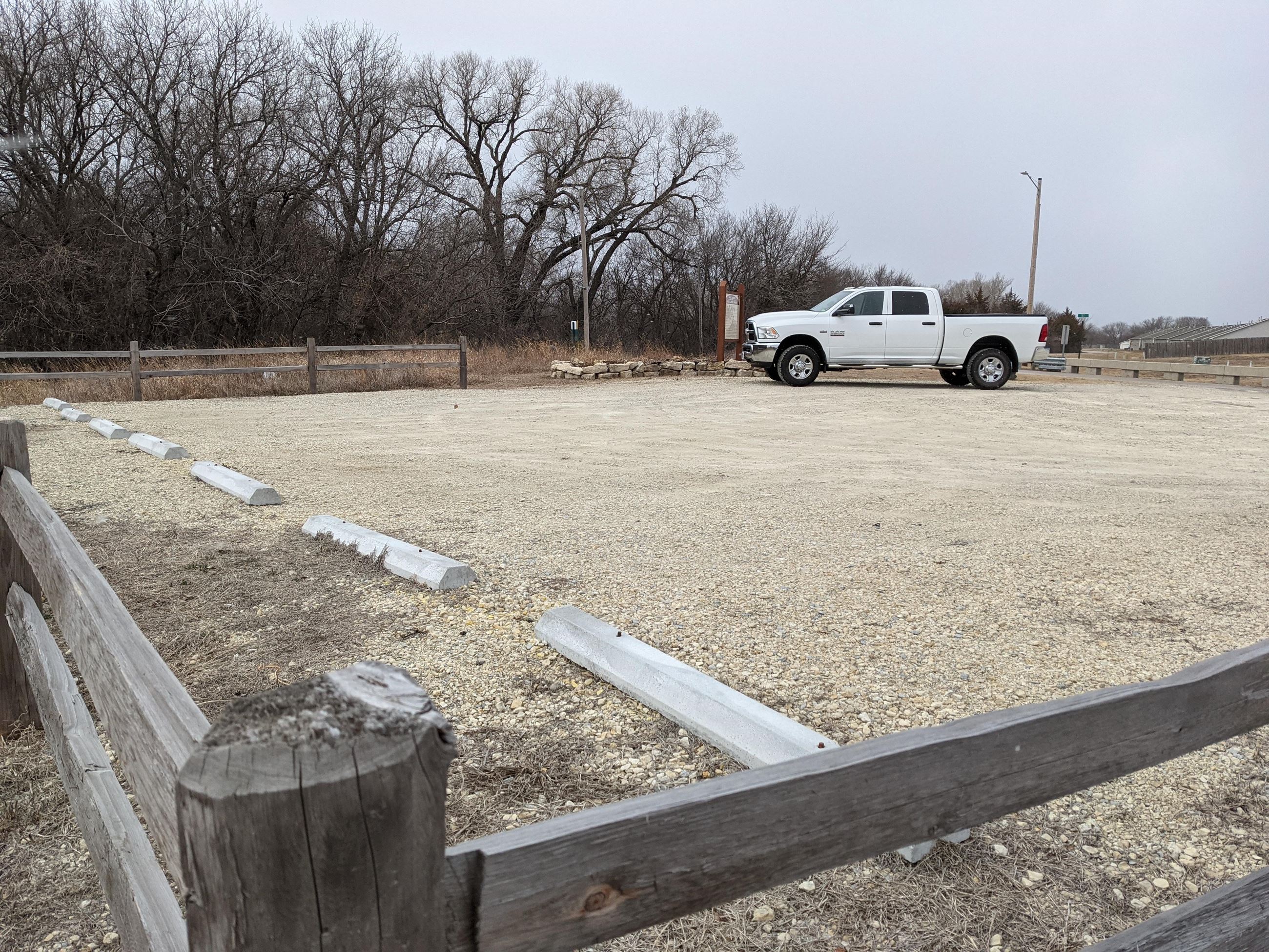 A white truck rests in a gravel lot
